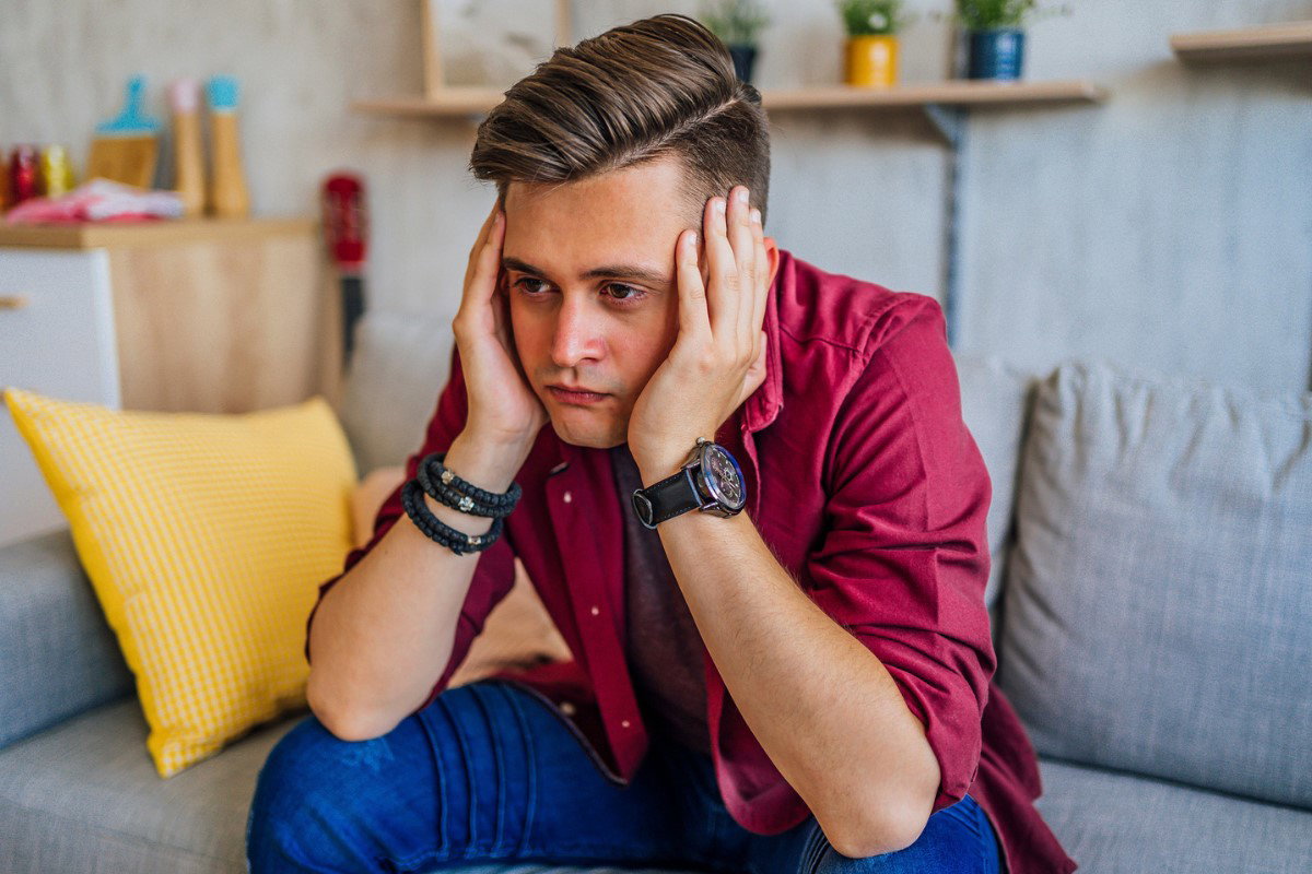 smutny mężczyzna siedzący na sofie