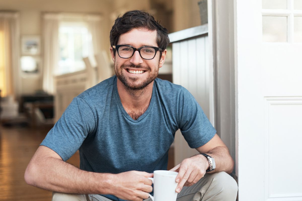 uśmiechnięty mężczyzna trzymający kubek