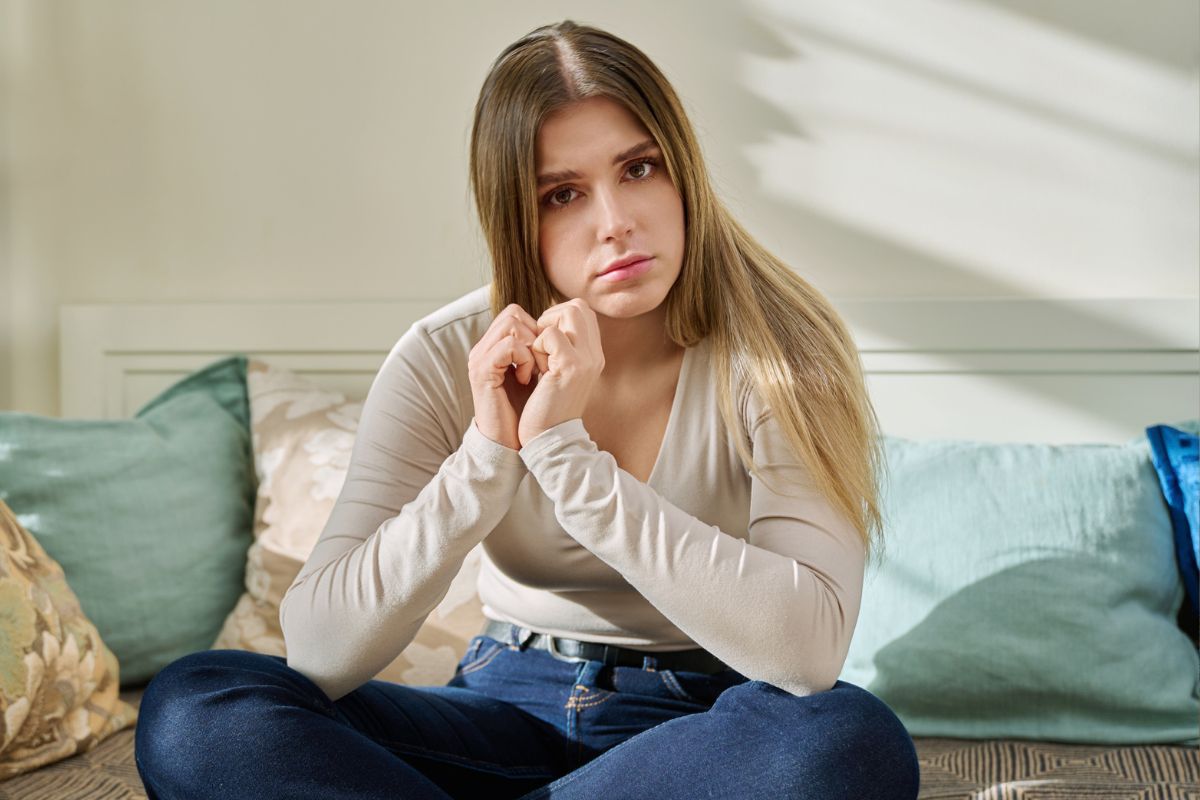 smutna kobieta siedzi na sofie, fot. Getty Images, TatyanaGl