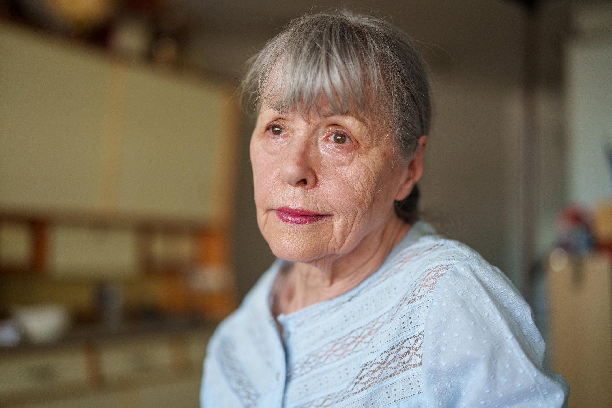 Senior woman with a sad look on face standing in kitchen