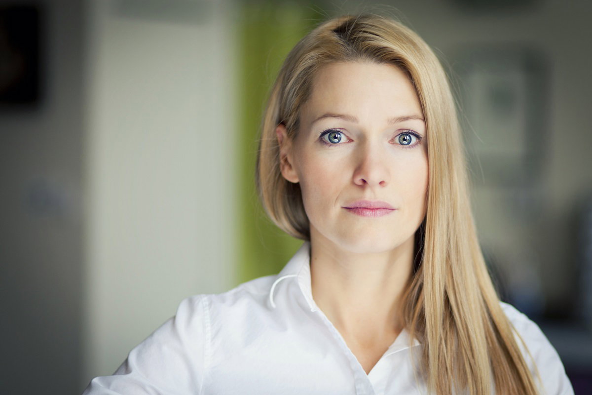 młoda kobieta z długimi blond włosami i w białej koszuli patrzy przed siebie z przerażeniem i rozczarowaniem