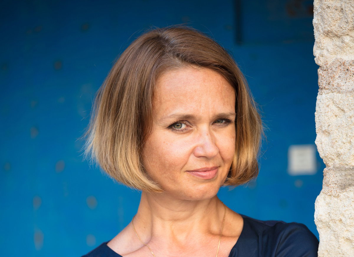 młoda kobieta z fryzurą na pazia patrzy przed siebie zawadiackim spojrzeniem