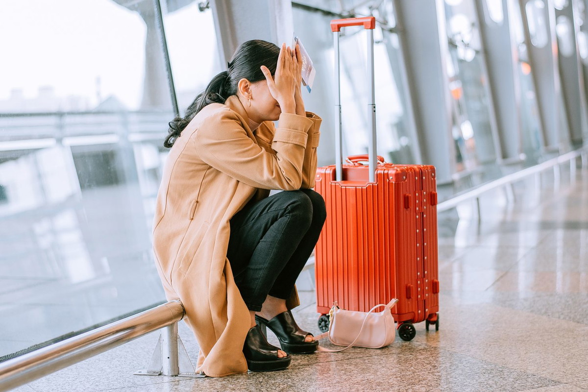 Young Asian woman upset and frustrated while flight canceled at the airport