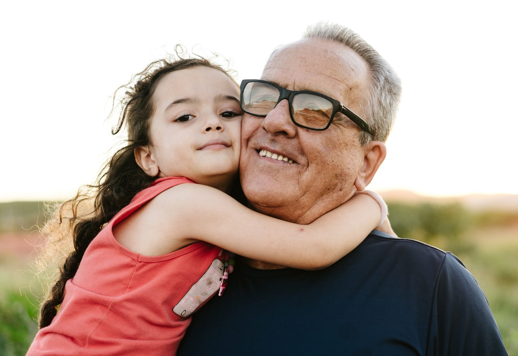 Granddaughter hugged with grandpa outdoors