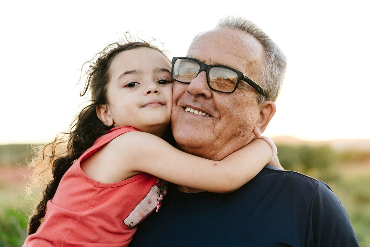 Granddaughter hugged with grandpa outdoors