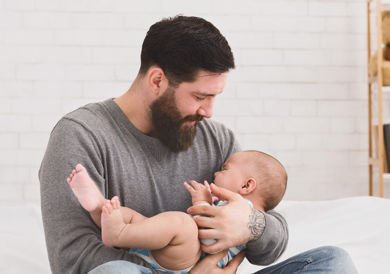 Father holding and soothing crying newborn baby in his arms