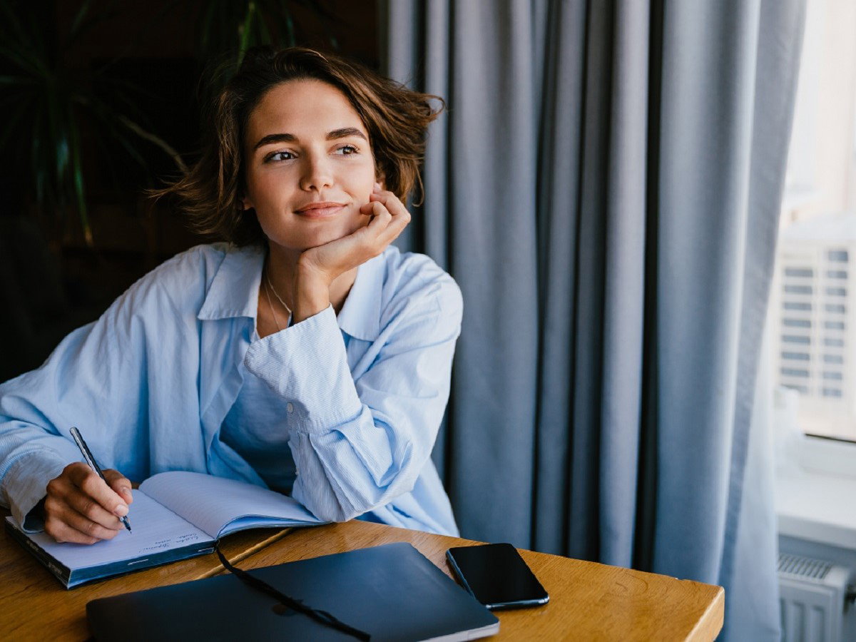 kobieta pisząca przy oknie