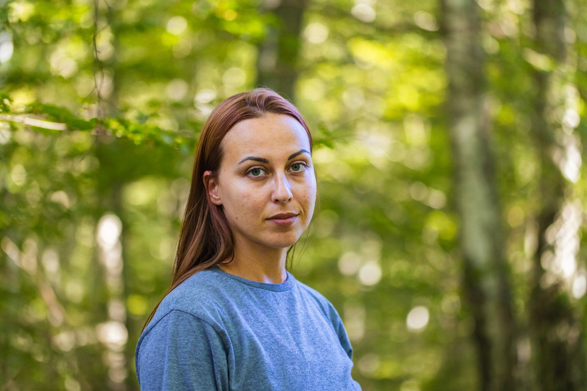 młoda kobieta z długimi włosami w wieku około 30 lat w niebieskich T-shircie na łonie natury stoi i m zrezygnowaną minę