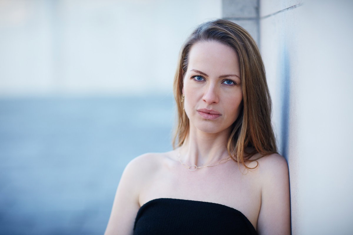 młoda kobieta w wieku około 30 lat z długimi włosami w czarnym bandeau patrzy smutnym wzrokiem