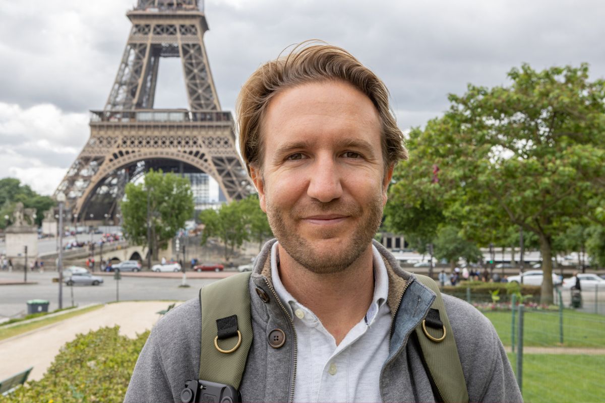 mężczyzna na tle wieży Eiffla