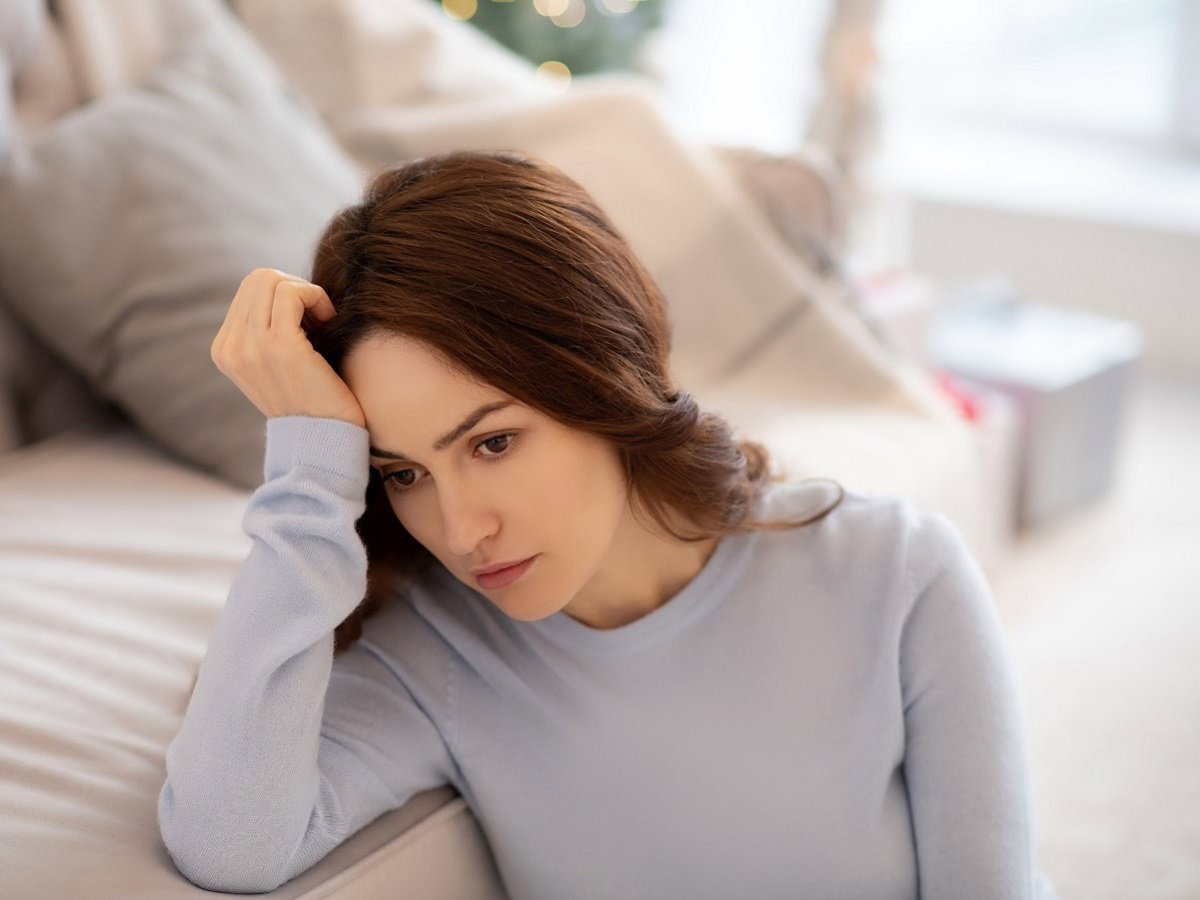 smutna dziewczyna siedząca w salonie