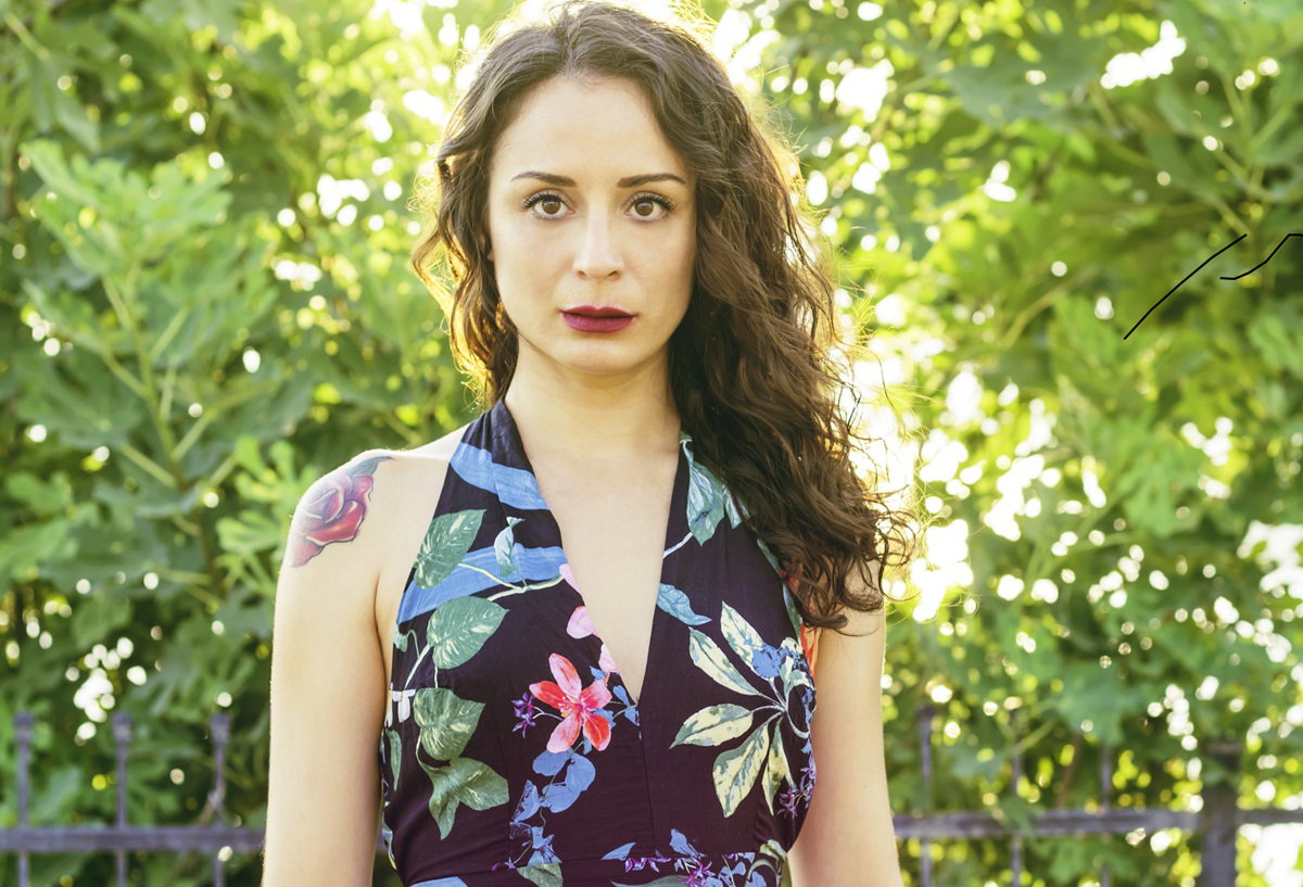 kobieta z długimi włosami w kwiecistej sukience na tle drzew