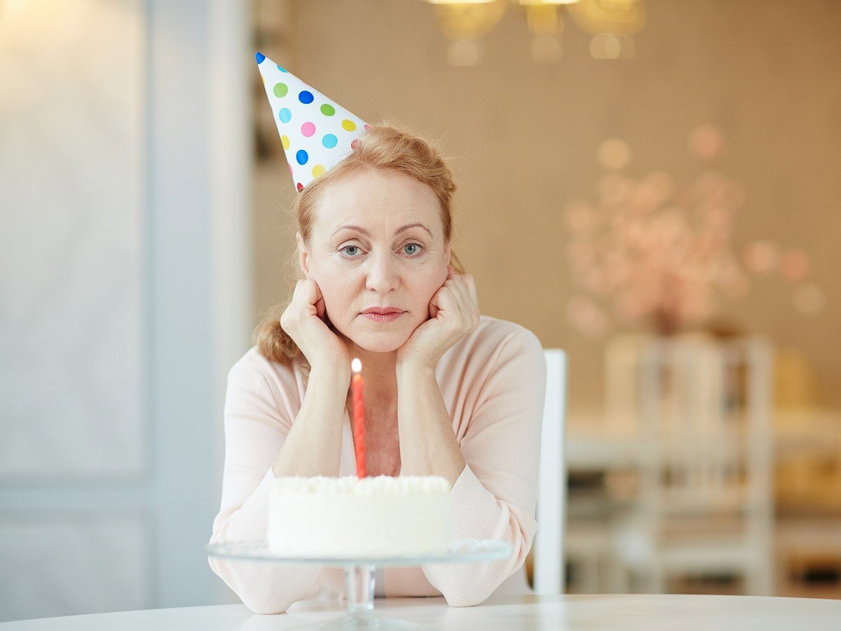 kobieta siędząca przy torcie