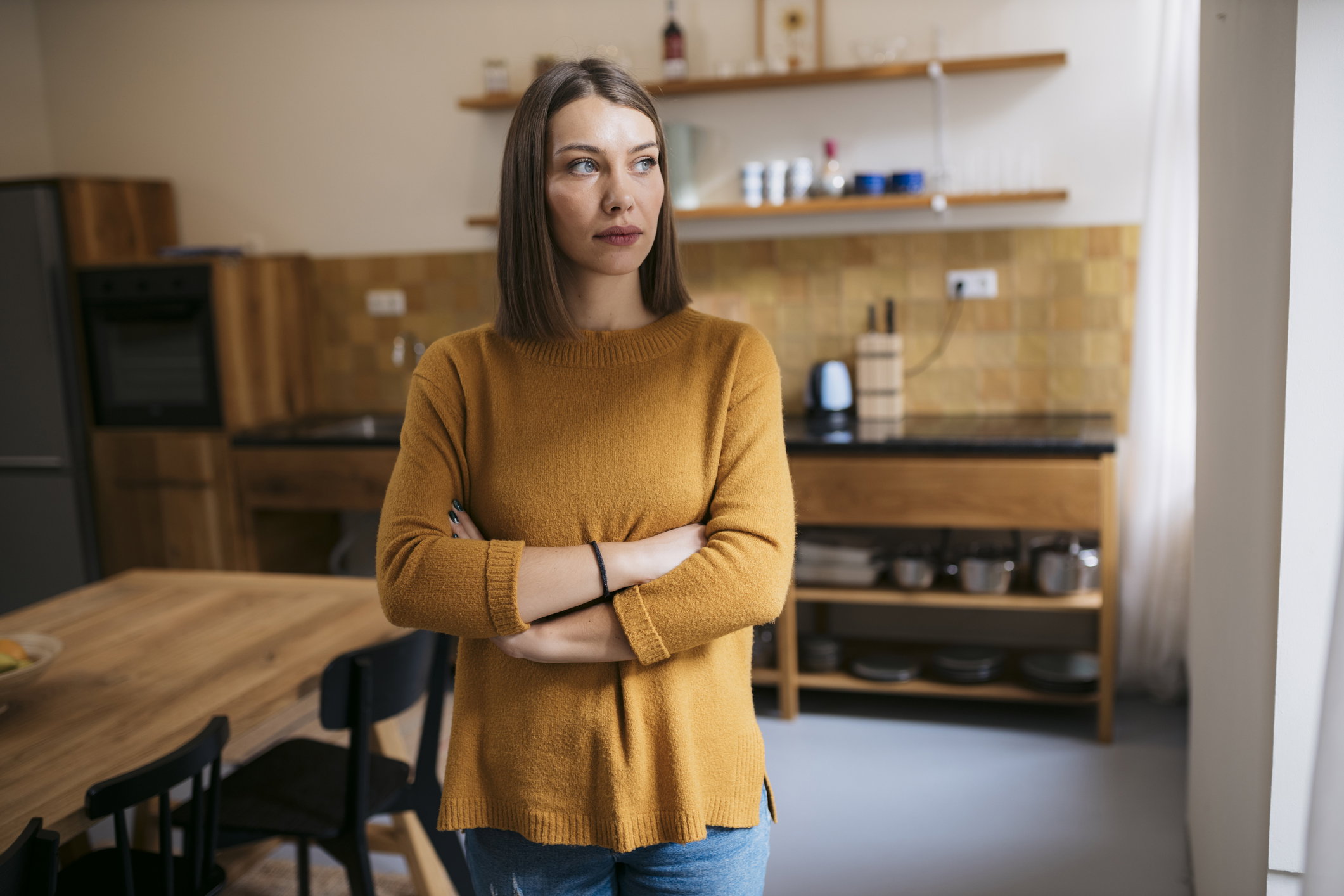 Portrait of thoughtful young woman standing at home and looking away