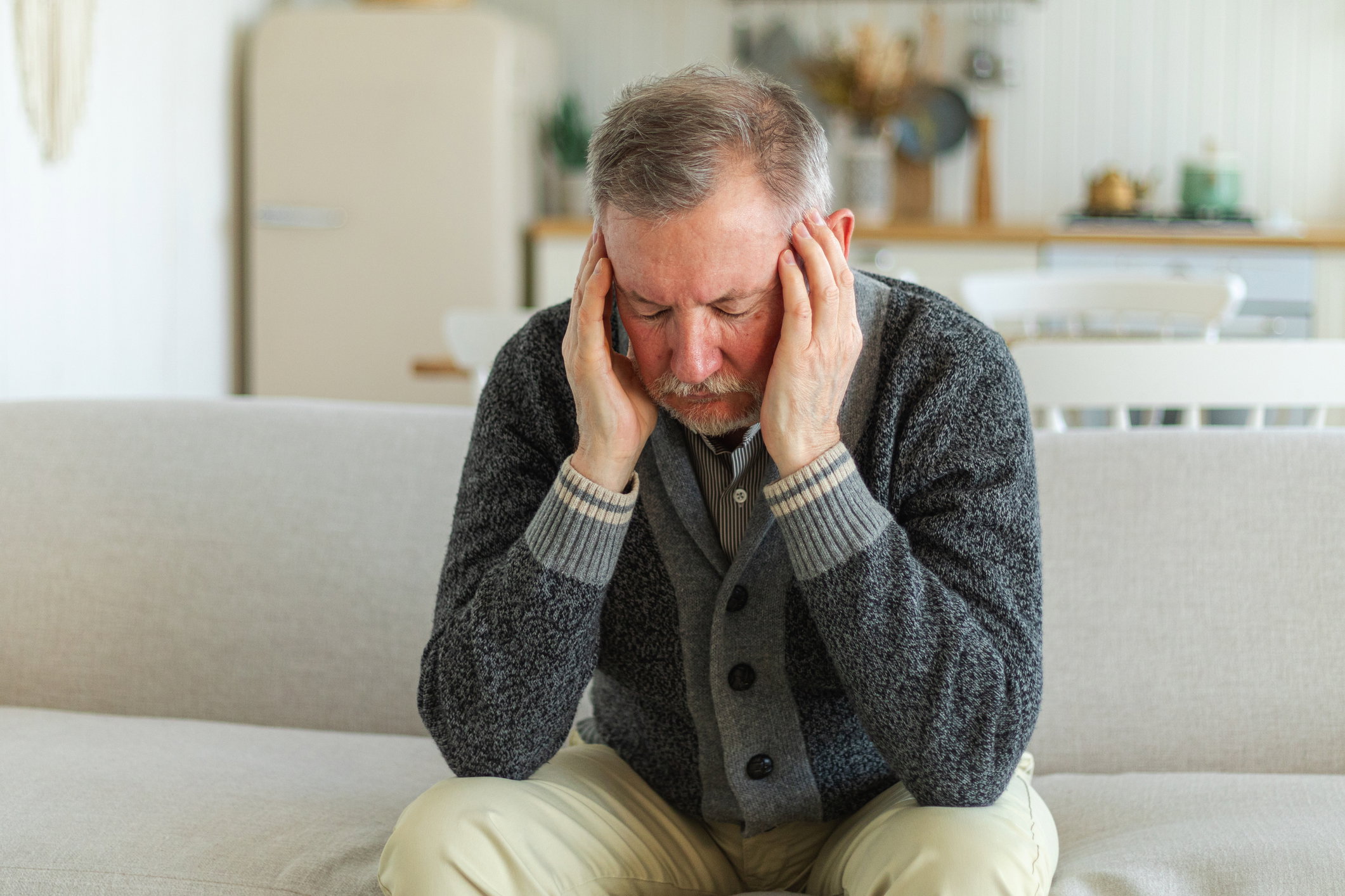 Headache pain. Unhappy middle aged senior man suffering from headache sick rubbing temples at home. Mature old senior grandfather touching temples experiencing stress. Man feeling pain hurt in head.
