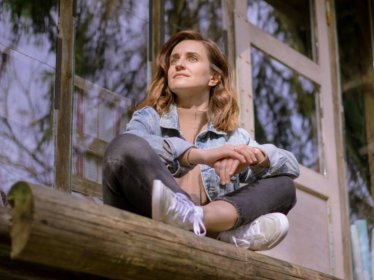 kobieta siedząca przed domem