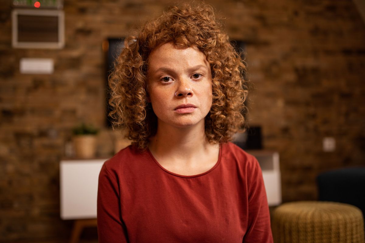 zmartwiona kobieta patrzy prosto w obiektyw aparatu