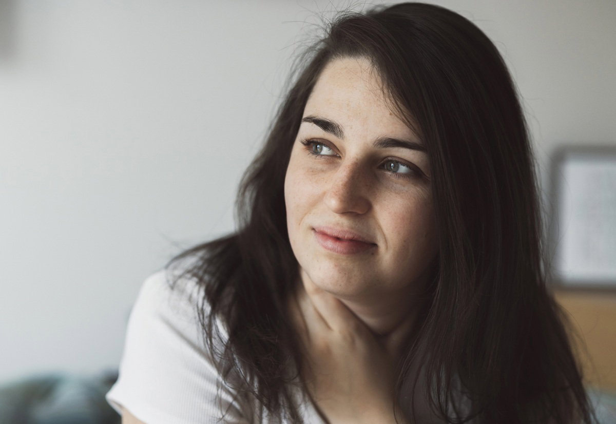 ciemnowłosa kobieta w wieku około 30 lat patrzy zamyślona w dal