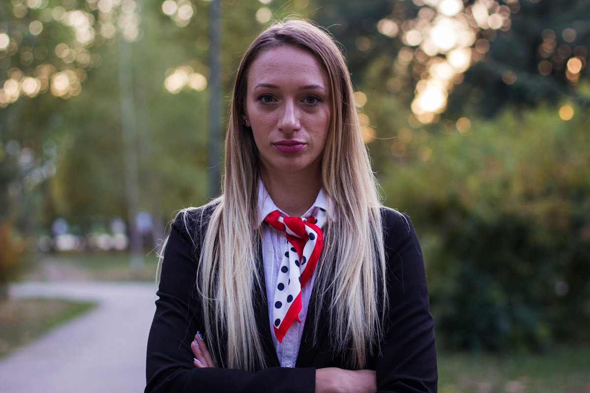 kobieta w wieku 30 plus blondynka z apaszką pod kołnierzykiem stoi zdenerwowana na zewnątrz