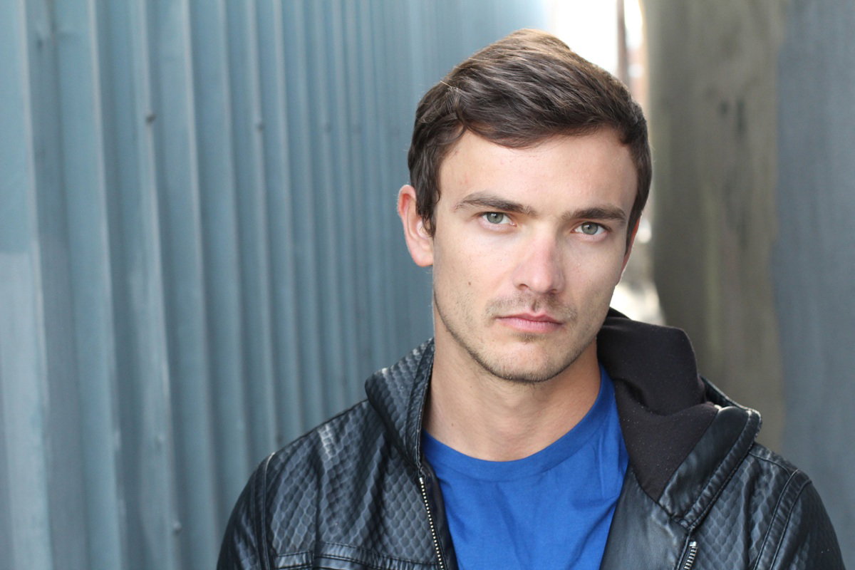 młody mężczyzna w kurtce stoi na zewnątrz i jest zasmucony