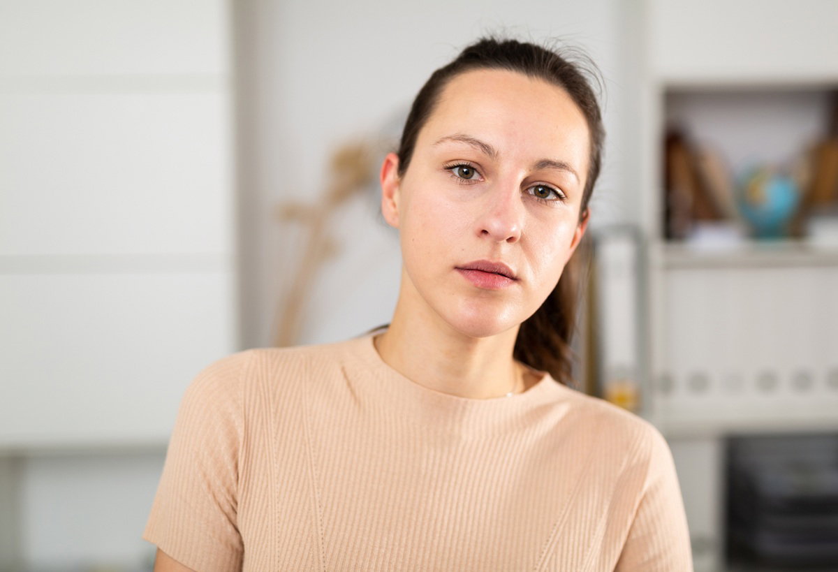 smutna kobieta w wieku około 30 plus stoi w salonie