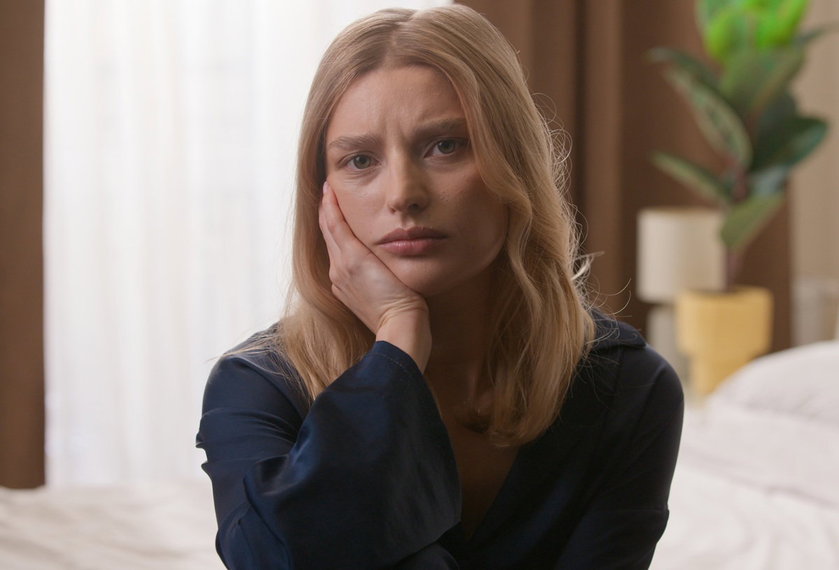 kobieta w wieku około 30 lat blondynka siedzi na łóżku zmartwiona i załamana