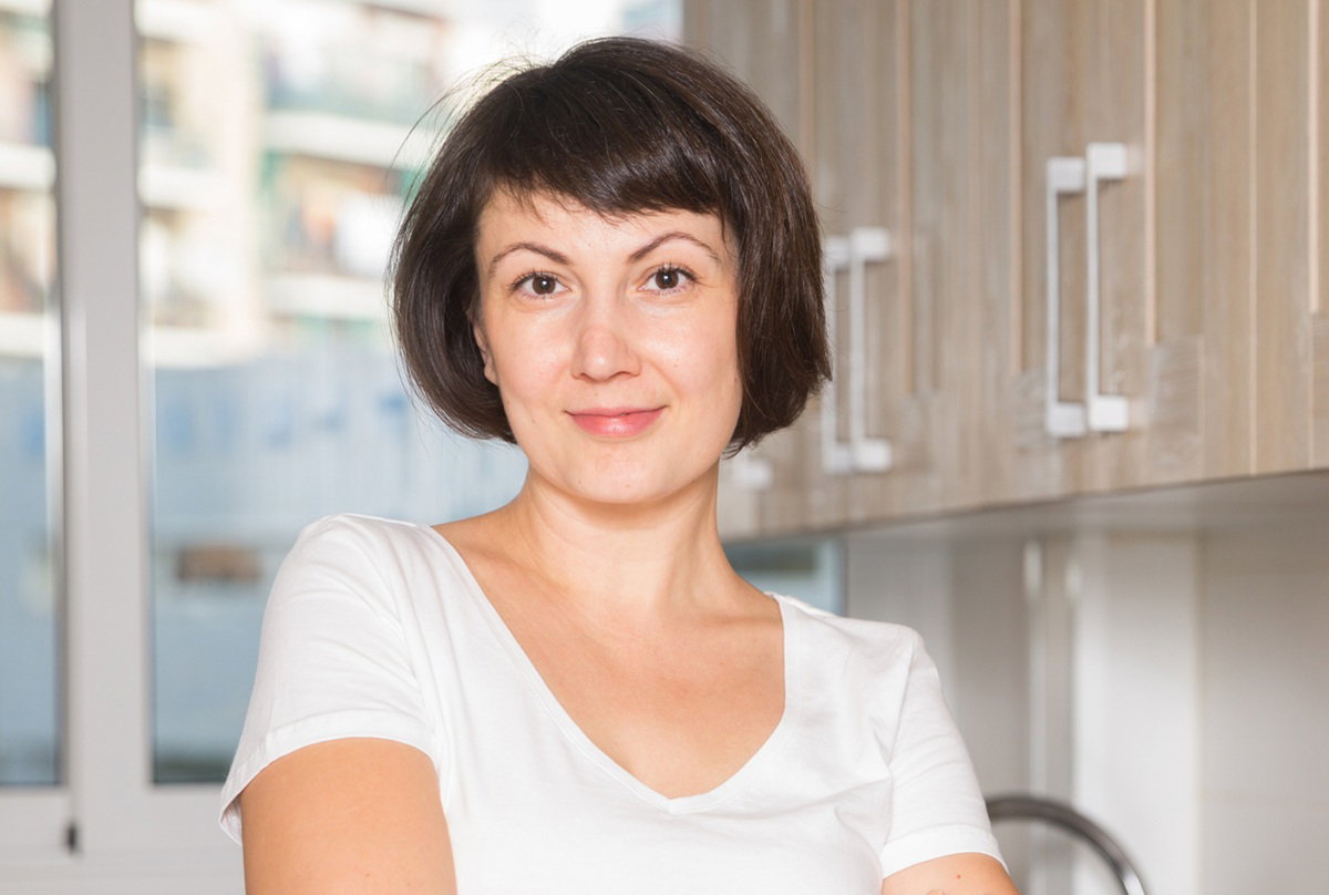 kobieta w wieku 40 plus stoi w kuchni i ma zaczepny wyraz twarzy