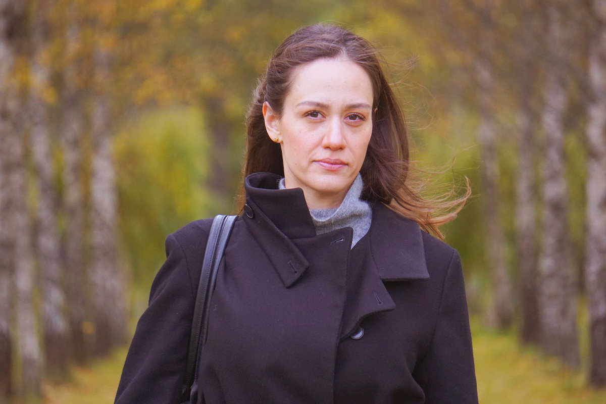 kobieta w wieku około 40 lat stoi na tle brzóz na wietrze smutna i zamyślona