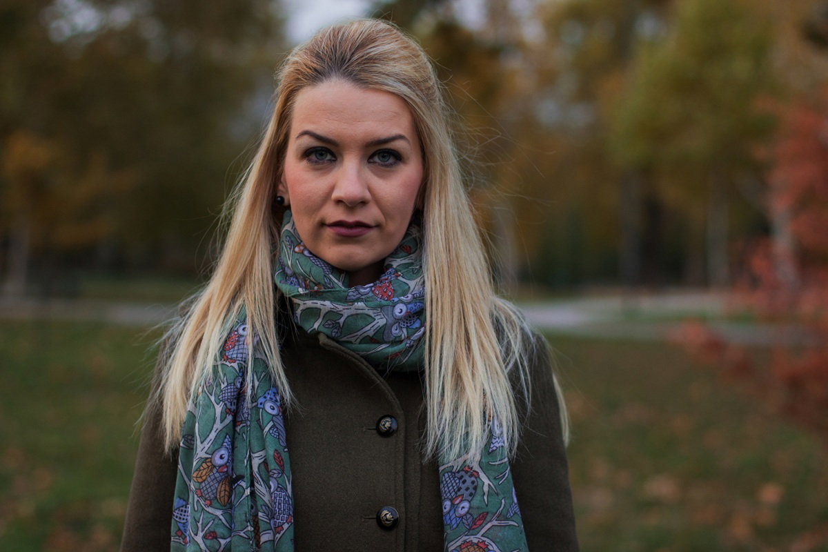 kobieta w wieku około 30 lat blondynka z chustą na szyi stoi na zewnątrz smutna i zła