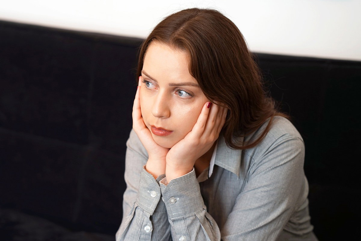 kobieta w wieku około 30 plus siedzi zmartwiona na kanapie