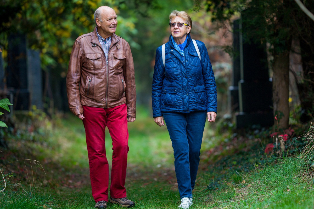 para seniorów 70 plus spaceruje po cmentarzu wczesną jesienną porą