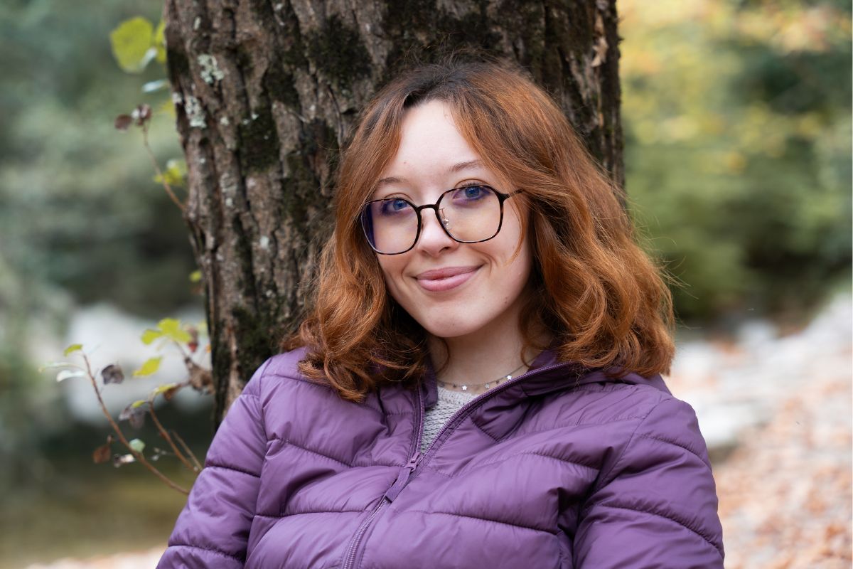 Kobieta opiera się o drzewo