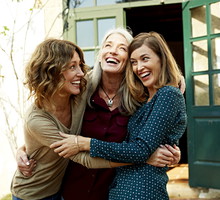 Mother and daughters embracing outdoors