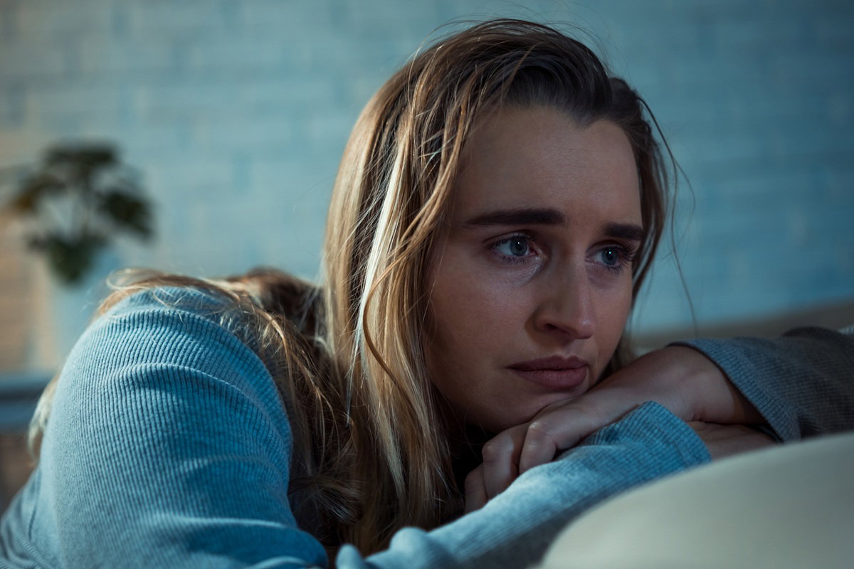 smutna kobieta 25 plus siedzi na kanapie załamana i rozmyśla