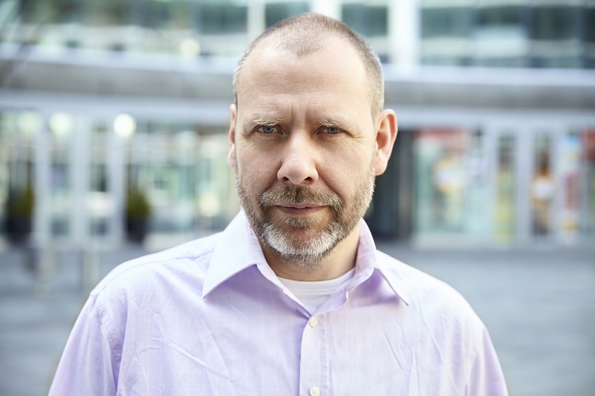 mężczyzna w wieku 45 plus w koszuli stoi na zewnątrz zamyślony i smutny