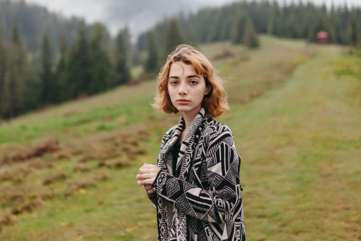 Smutna młoda kobieta w górach