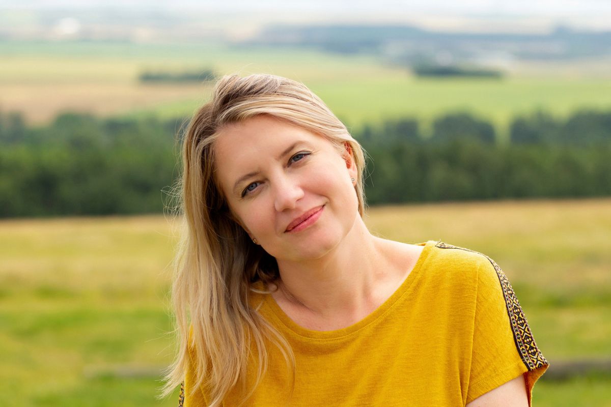 kobieta w żółtej bluzce na łące