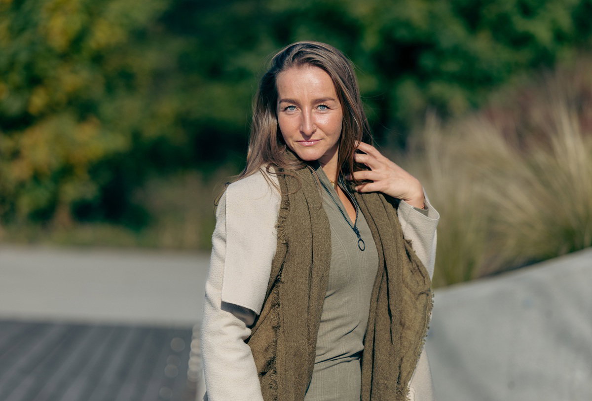 kobieta w wieku 35 plus z jasnymi długimi włosami na zewnątrz patrzy zalotnie stojąc w słońcu