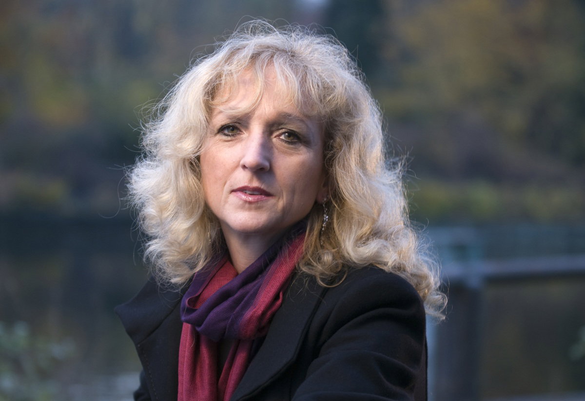 kobieta w wieku 50 plus blondynka stoi na zewnątrz zamyślona i smutna