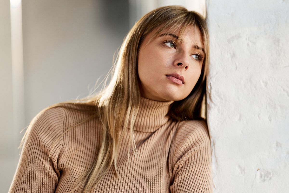 kobieta oparta o ścianę