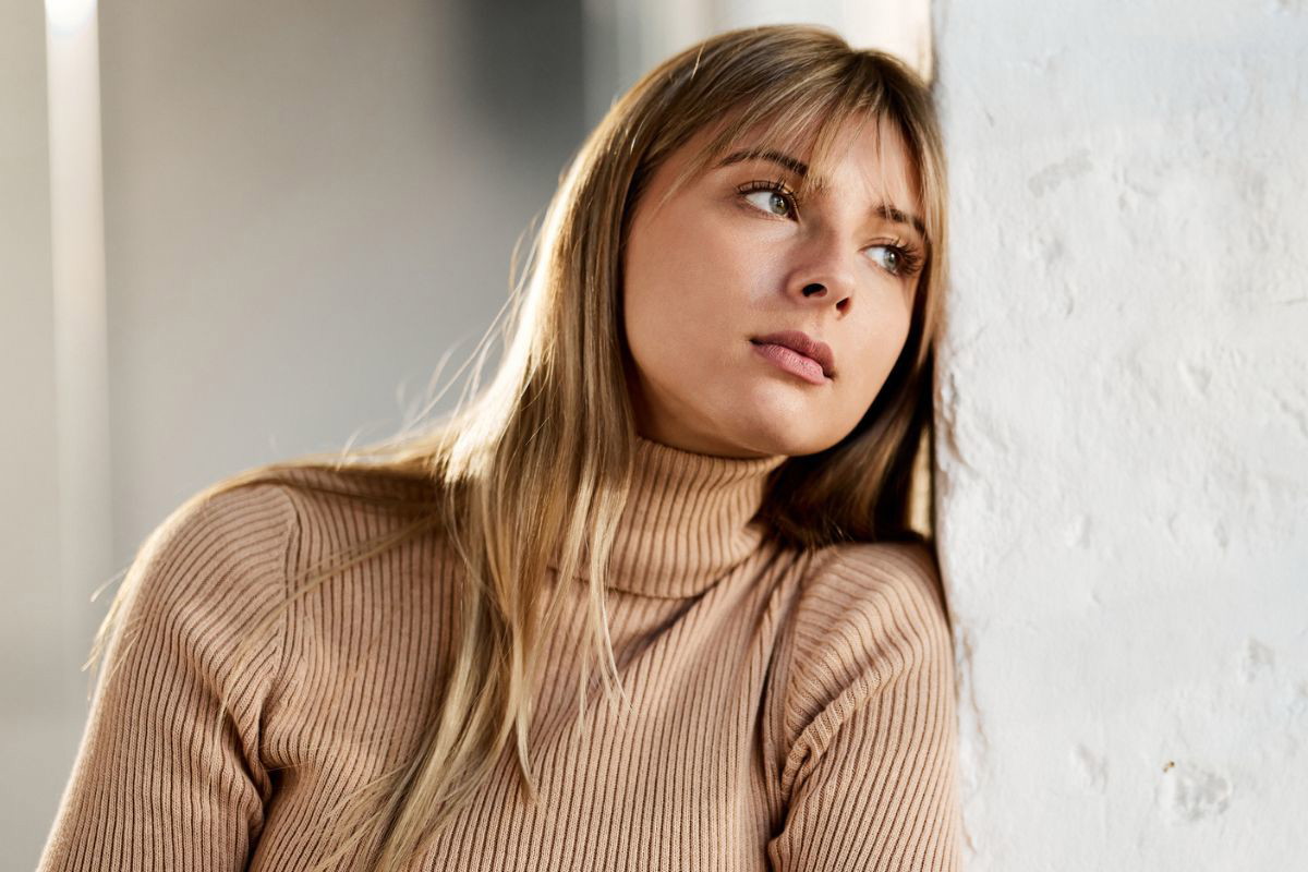 kobieta oparta o ścianę