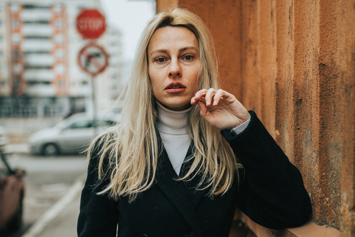 kobieta blondynka w wieku 30 plus stoi na ulicy zrozpaczona