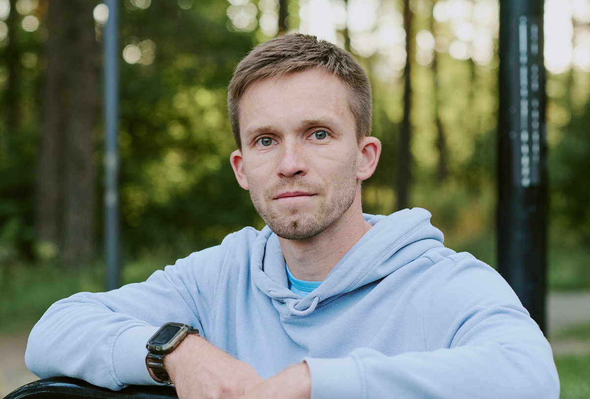 mężczyzna w wieku 30 plus w jasnej bluzie stoi na zewnątrz smutny i zamyślony