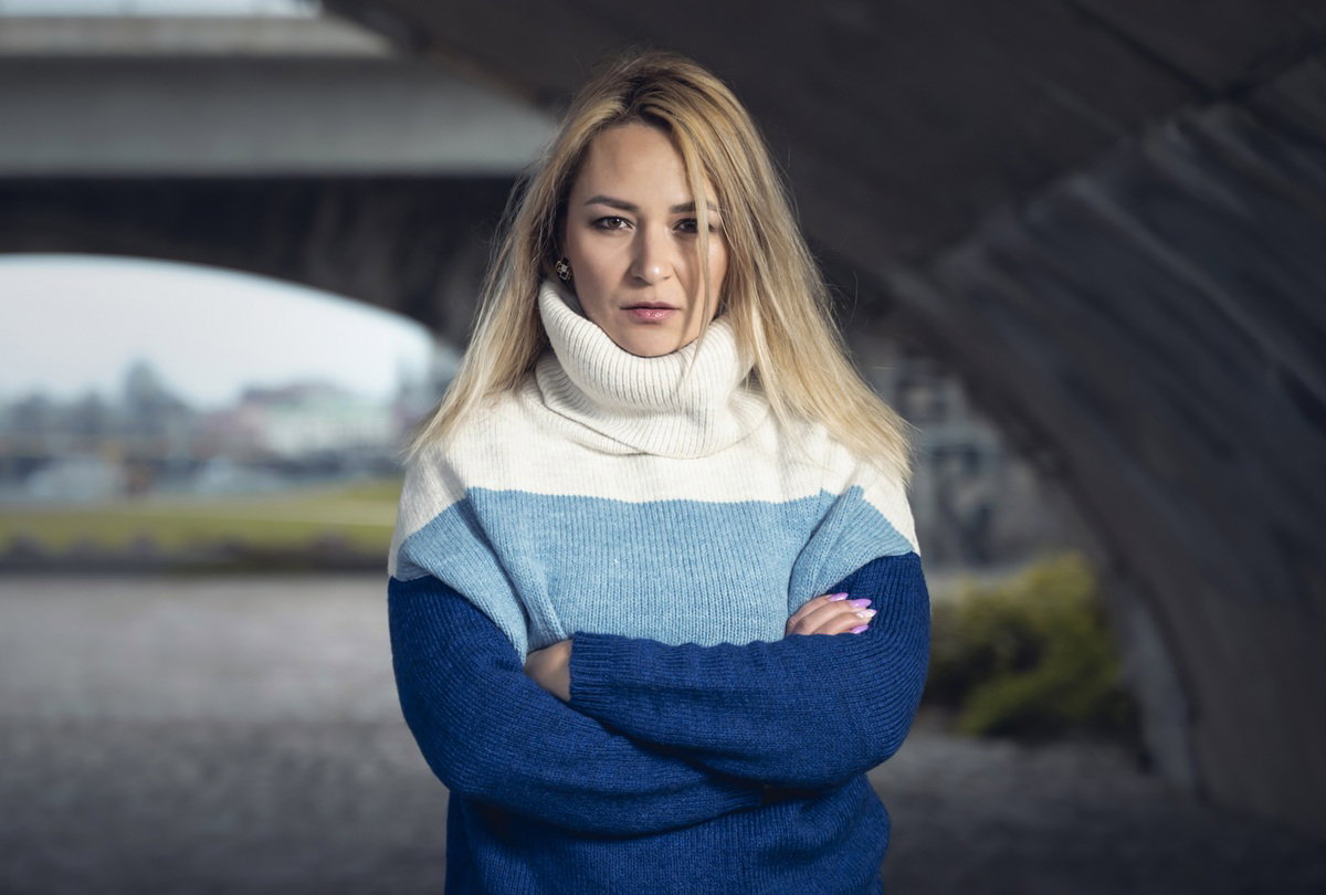 kobieta w wieku 30 plus blondynka stoi na zewnątrz zaciętą twarzą i skrzyżowanymi ramionami