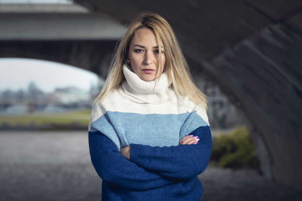 kobieta w wieku 30 plus blondynka stoi na zewnątrz zaciętą twarzą i skrzyżowanymi ramionami
