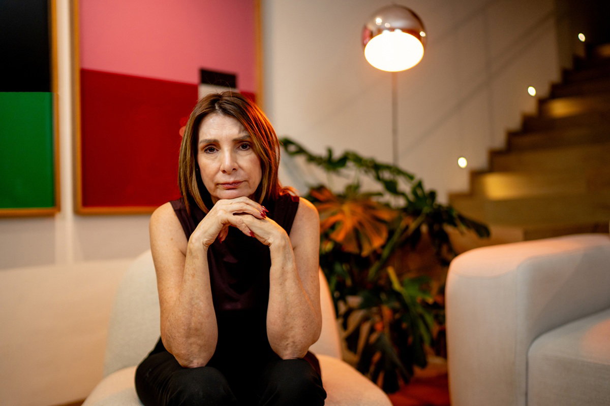 kobieta w wieku 55 plus w małej czarnej siedzi w salonie i załamuje ręce zmartwiona