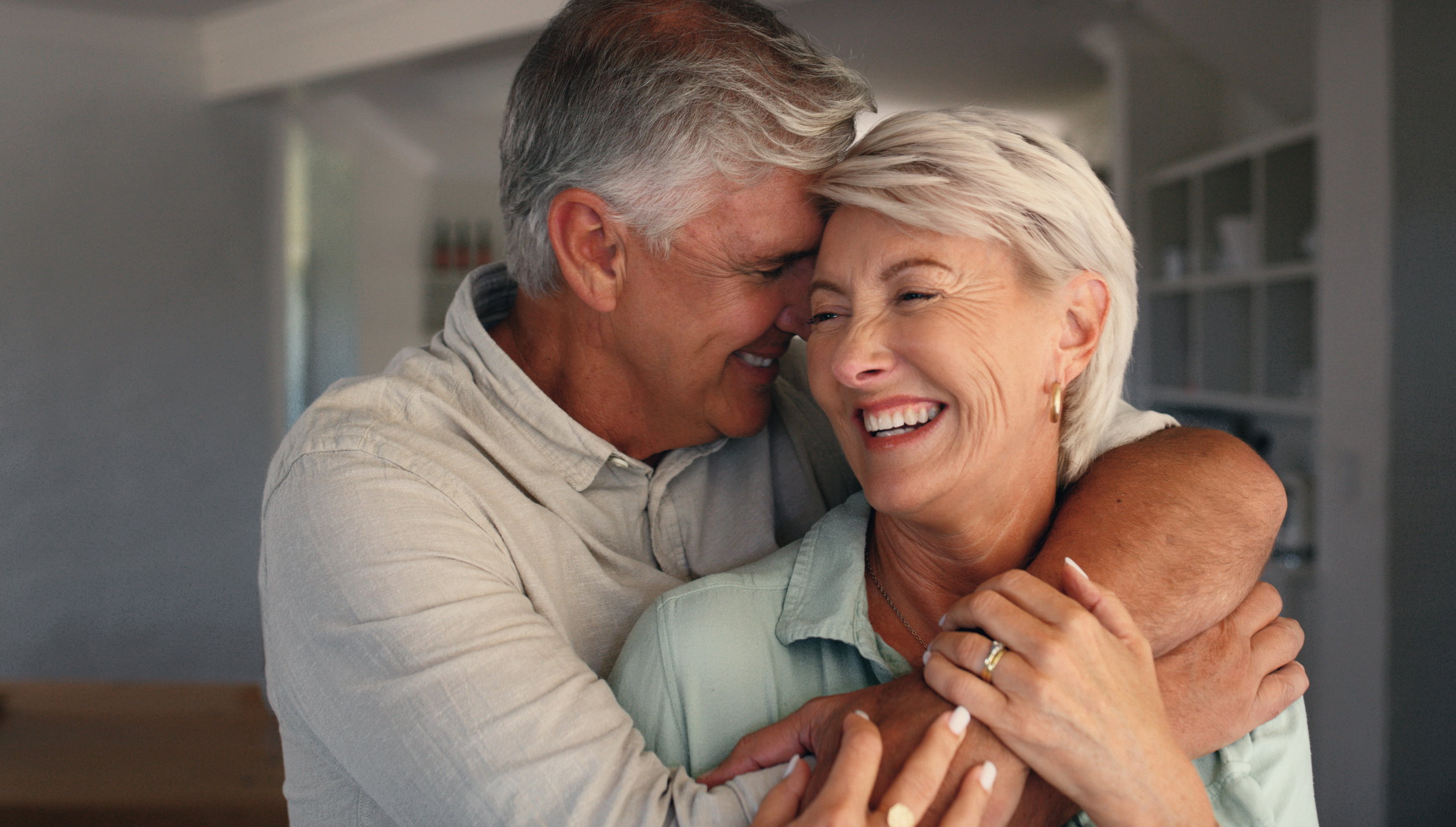 Home, hug and senior couple with love, funny and bonding together with happiness, trust and care. Laughing, old man or mature woman in house, embrace or relationship with marriage or smile with humor