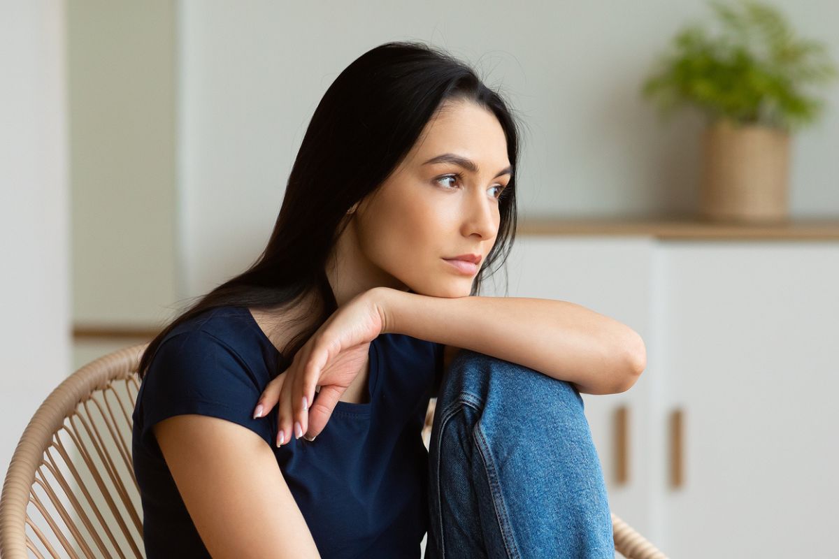 zamyślona kobieta w ciemnych włosach