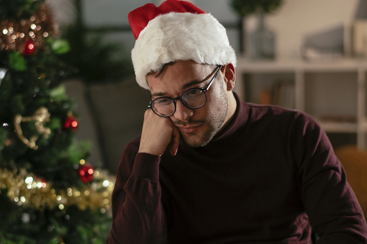 smutny mężczyzna przy choince