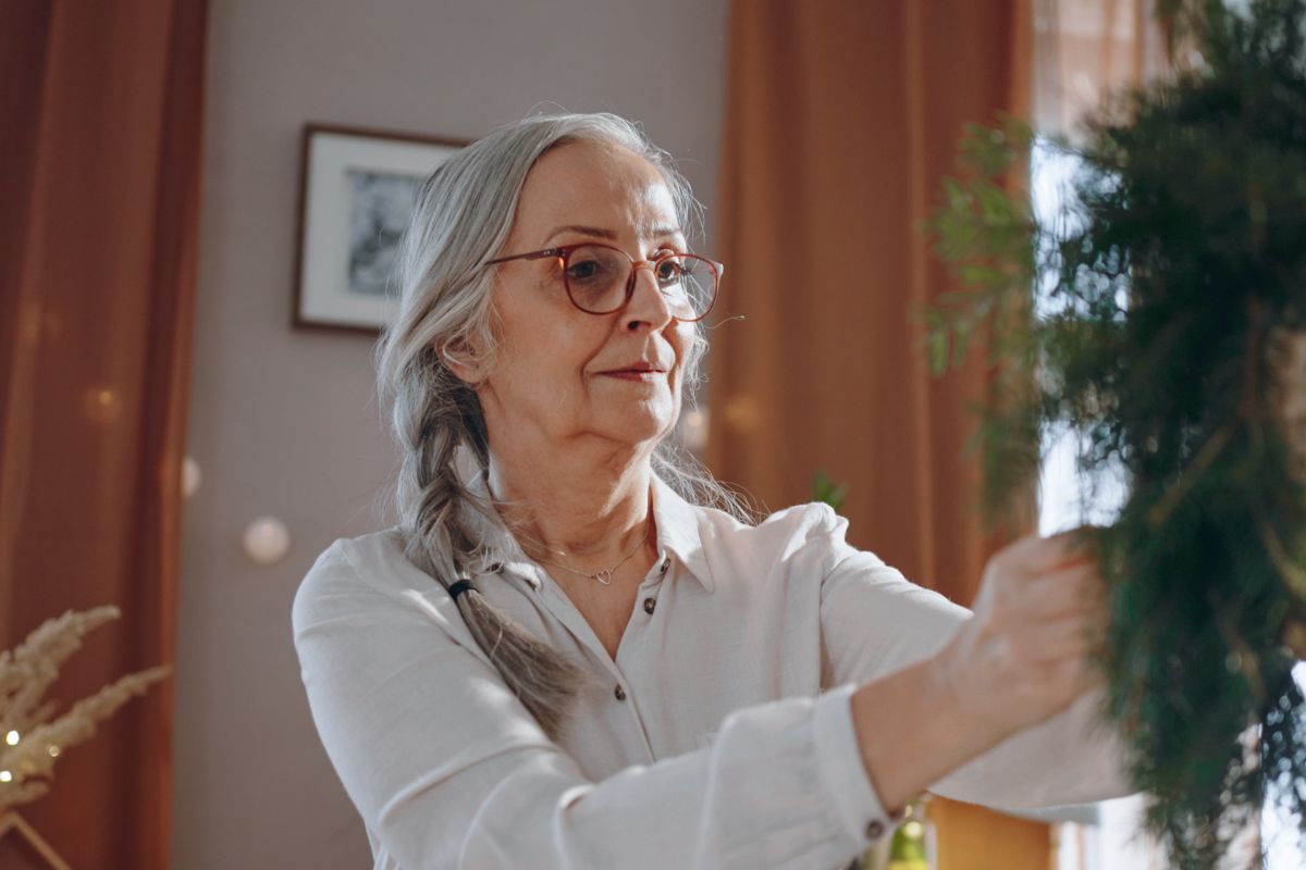 starsza kobieta robiąca stroik świąteczny